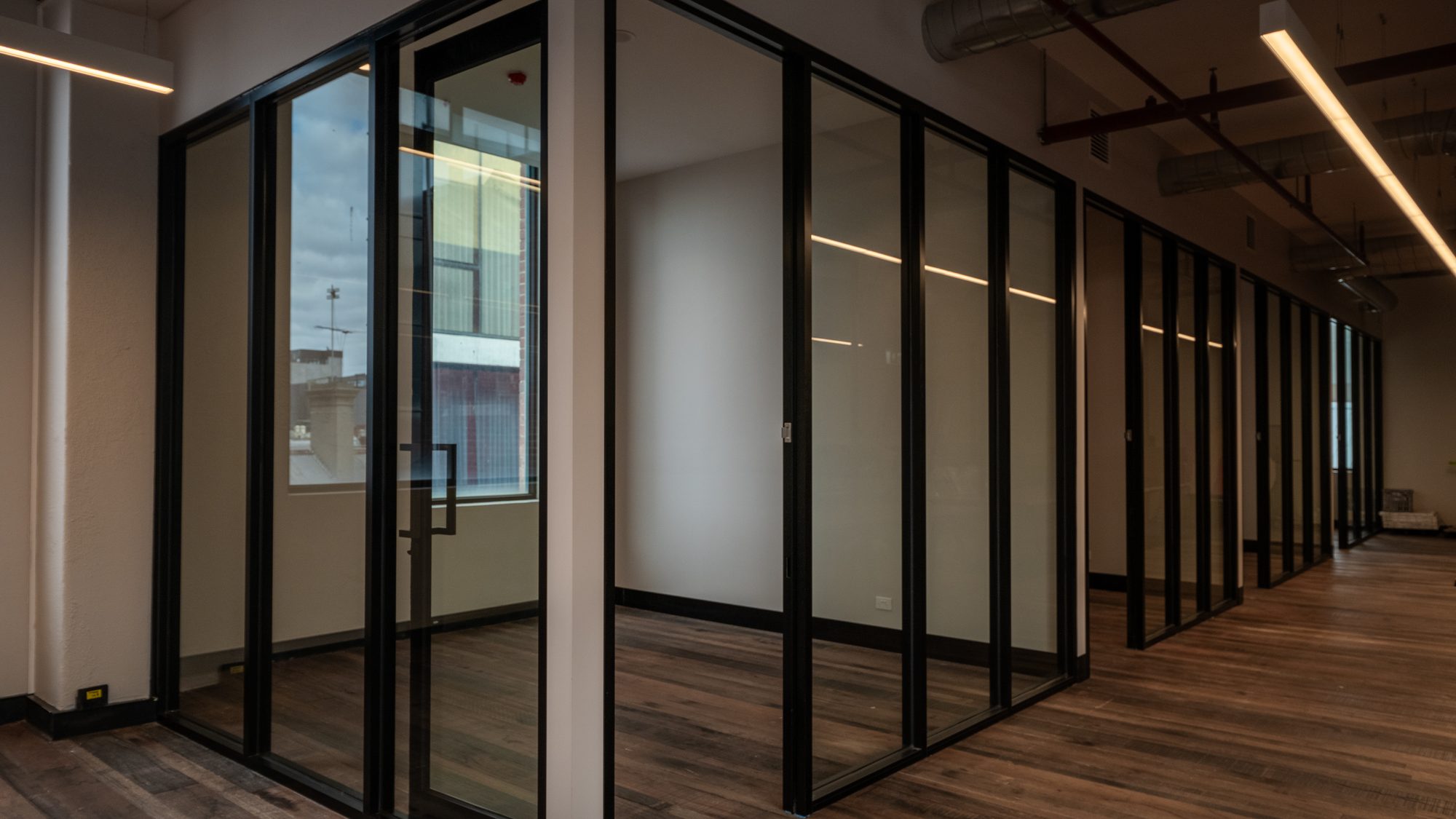 Black-framed glass partition walls through an office fit-out in South Melbourne