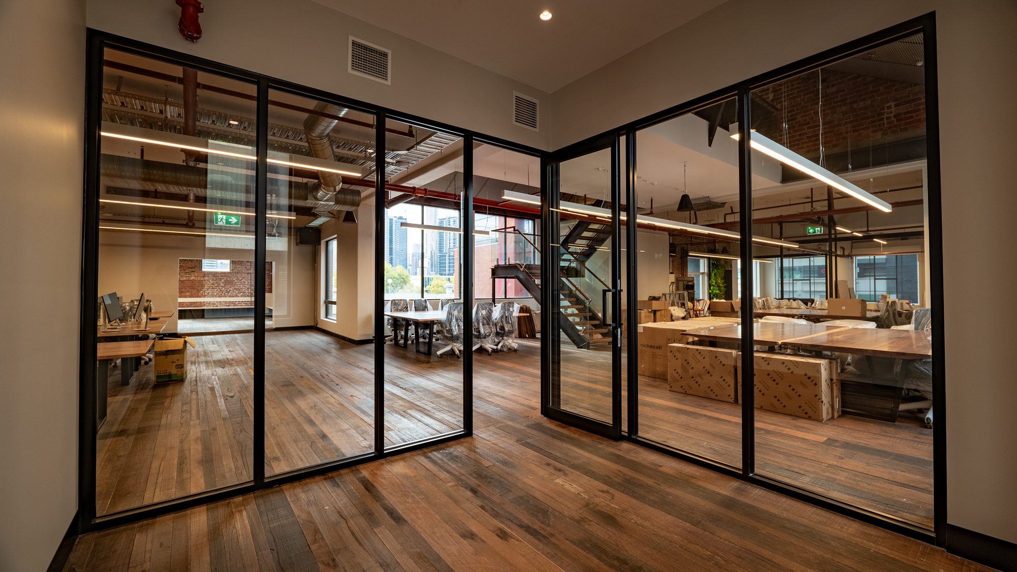 Corner glass partition looking over an open-plan office